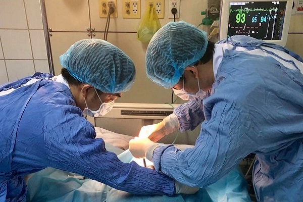 Các bác sĩ tiến hành mở khí quản, tạo đường thở cho bệnh nhân - Ảnh: BSCC