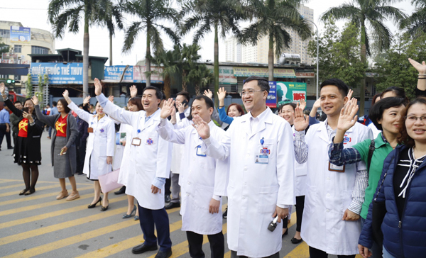 Lãnh đạo bệnh viện và bệnh nhân vẫy chào nhau khi xe lăn bánh