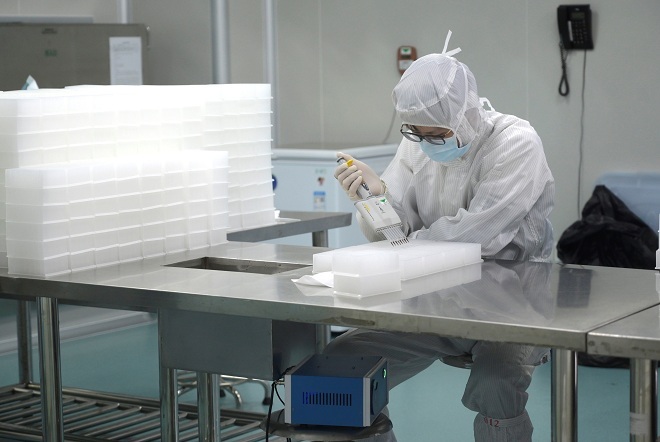 Bác sĩ tại tỉnh Quảng Đông đang tiến hành xét nghiệm mẫu bệnh phẩm corona. Ảnh: Reuters