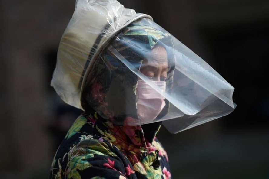 Một người dân trang bị bảo vệ cơ thể tại một khu dân cư ở Vũ Hán (Ảnh: Reuters)
