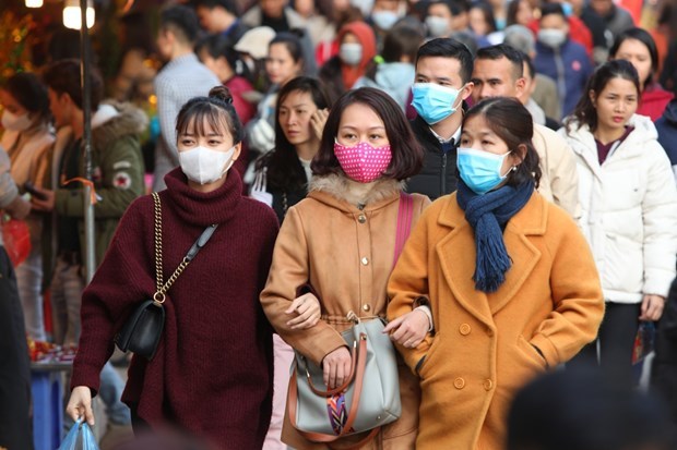 Many people wear face masks while visiting Tay Ho Temple, a place of worship attracting a large number of visitors after the Lunar New Year festival in Hanoi