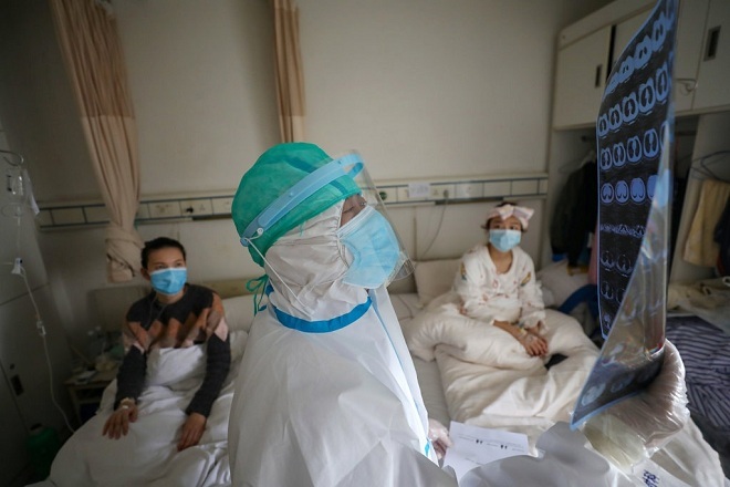 Nhân viên y tế Bệnh viện Chữ thập đỏ tỉnh Hồ Bắc đọc kết quả chụp CT phổi của các bệnh nhân tại khu cách ly. Ảnh: Reuters