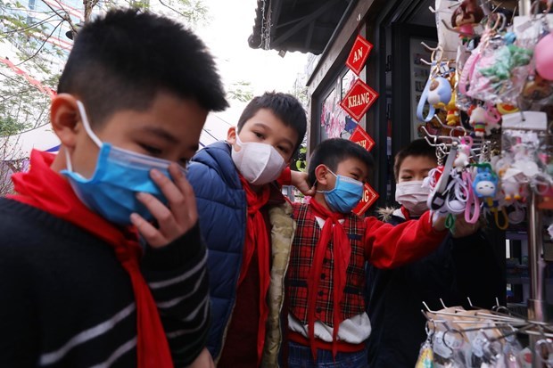 Children wear facemasks while visiting the Hanoi Book Street on January 31