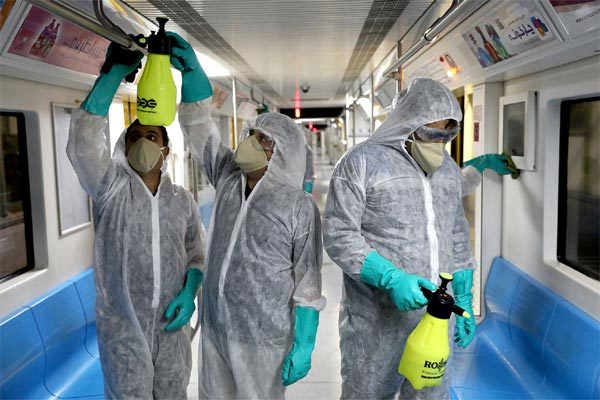 Các nhân viên mặc đồ bảo hộ đang tiến hành khử trùng cho các tàu điện ngầm ở thủ đô Tehran, Iran. Ảnh: AP