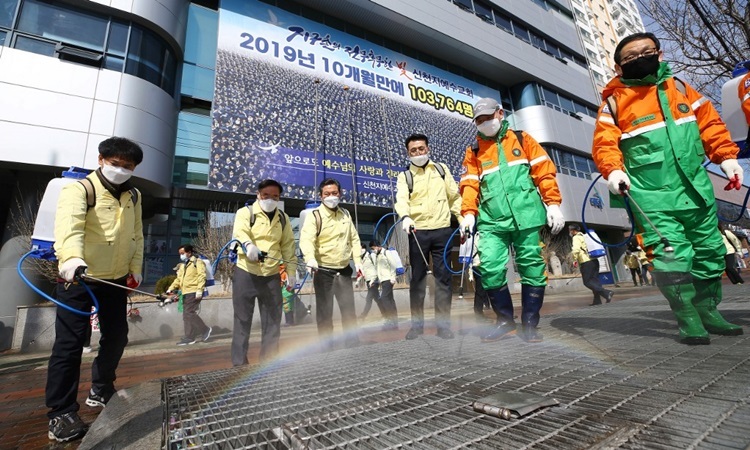 Chính quyền Hàn Quốc phun thuốc khử trùng trước chi nhánh nhà thờ Tân Thiên Địa ở thành phố Daegu hôm 6/3. Ảnh: AFP.