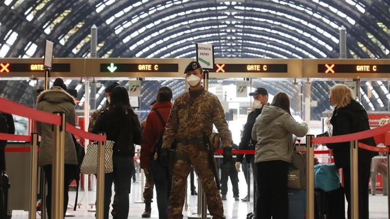 Cảnh sát và sĩ quan quân đội kiểm soát các hành khách tại ga tàu trung tâm thành phố Milan, Italia