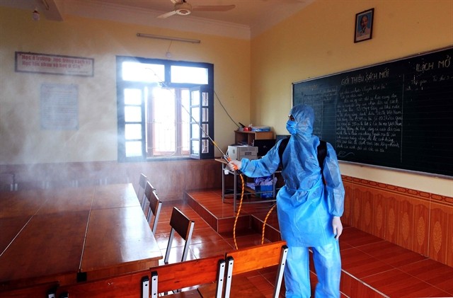 A medical worker sterilises a classroom in Hai Phong City on Thursday before readmitting students.