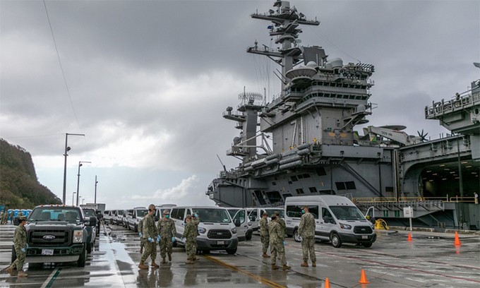 Binh sĩ Mỹ tham gia đưa các thủy thủ không nhiễm nCoV rời tàu sân bay USS Theodore Roosevelt tới khu cách ly tại căn cứ hải quân Guam, ngày 3/4. Ảnh: US Navy.