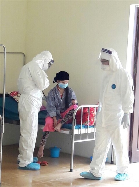 Two health workers check on a patient in the northern province of Ha Giang's Dong Van District.