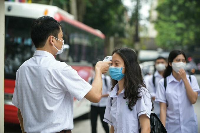 Giáo viên đo thân nhiệt tại cổng trường THPT Tô Hiến Thành, Thanh Hoá. Ảnh:Lê Hoàng.