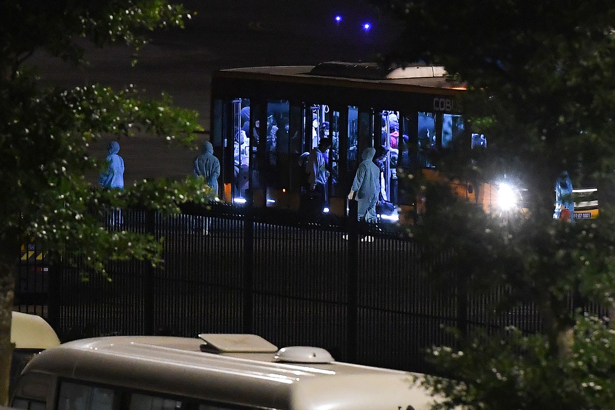 Hành khách lên xe bus để vào khu vực làm thủ tục nhập cảnh, khai báo, kiểm tra y tế.