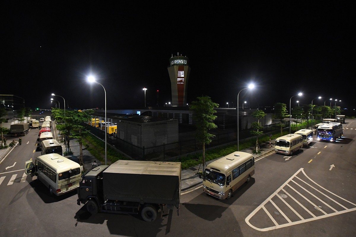 Đoàn xe của quân đội chờ sẵn bên ngoài để đón các hành khách về nơi cách ly.