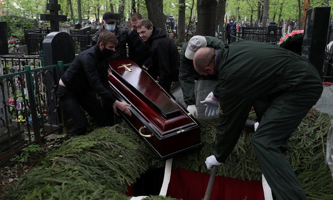 Nhân viên tang lễ chôn cất người chết vì Covid-19 ở Moskva , ngày 9/5. Ảnh: Reuters.