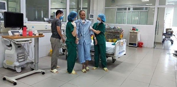 H.'s son and caregivers help her in a physical therapy session. — Photo Kenh 14