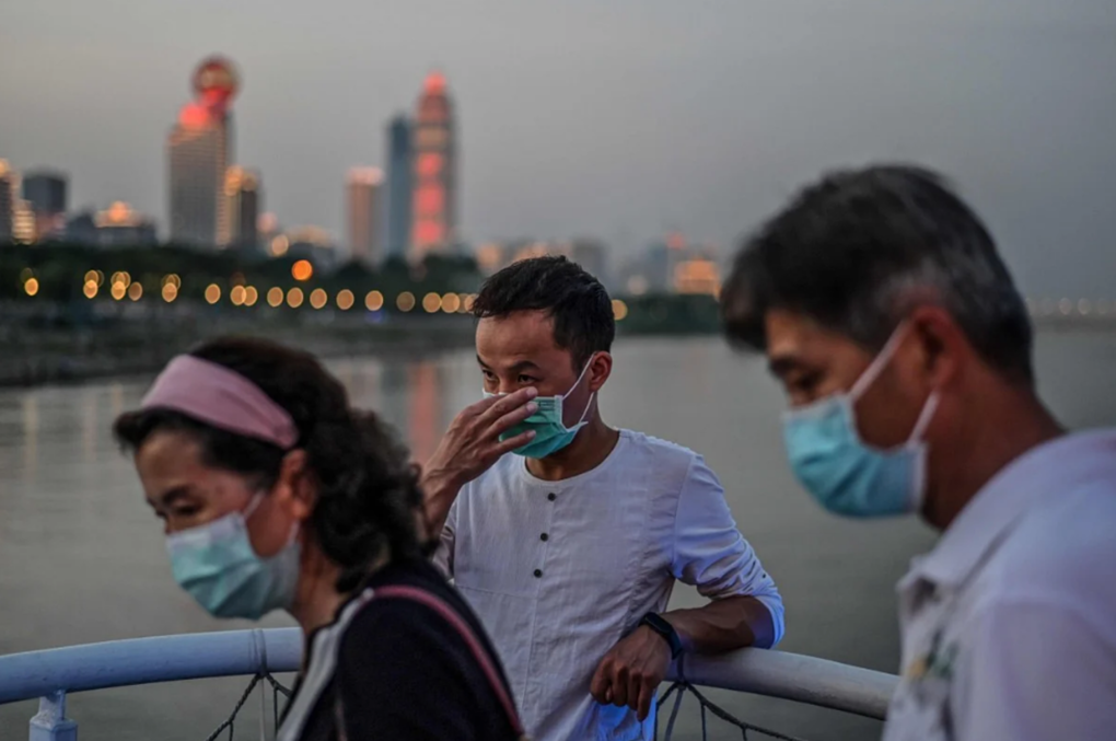 Người dân Vũ Hán đeo khẩu trang khi đi dạo tại bờ sông Yangtze, ngày 23/5. Ảnh: AFP