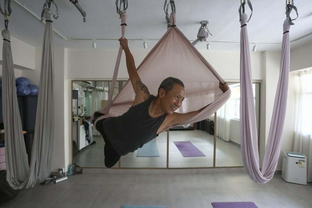 Ông Lau thực hành các động tác yoga bay tại một lớp học ở Jordan, Hong Kong. Ảnh: Jonathan Wong