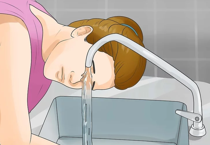 Rửa mắt dưới vòi nước chảy. Ảnh: Wikihow.