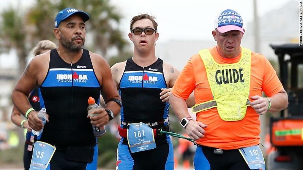 Chris Nikic và người hướng dẫn Dan Grieb (bên phải) đang trong đường chạy của Ironman Florida. Ảnh: CNN