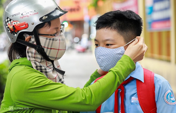 Ngày 8/5/2020, học sinh tiểu học Đinh Tiên Hoàng (quận 1, TP HCM) đến trường học sau hơn 3 tháng nghỉ vì Covid-19. Các em được đo thân nhiệt, rửa tay, đeo khẩu trang trước khi vào lớp. Ảnh: Quỳnh Trần.