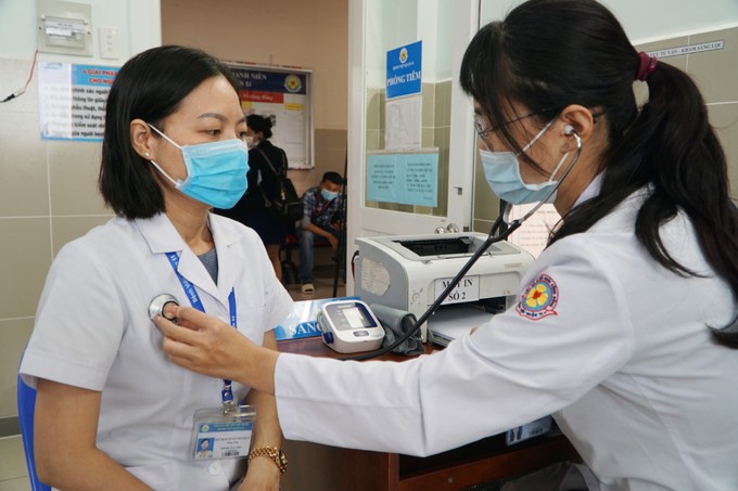 Dược sĩ Bích Hồng được đo nhịp tim và khai thác tiền sử dịch tễ trước khi tiêm vaccine Covid-19. Ảnh: Thư Anh.