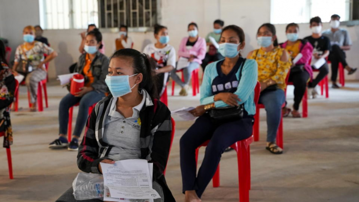 Garment factory workers and staff wait to receive China's Sinovac coronavirus vaccine at an industrial park in Phnom Penh, Cambodia, April 7, 2021. Photo by Reuters.