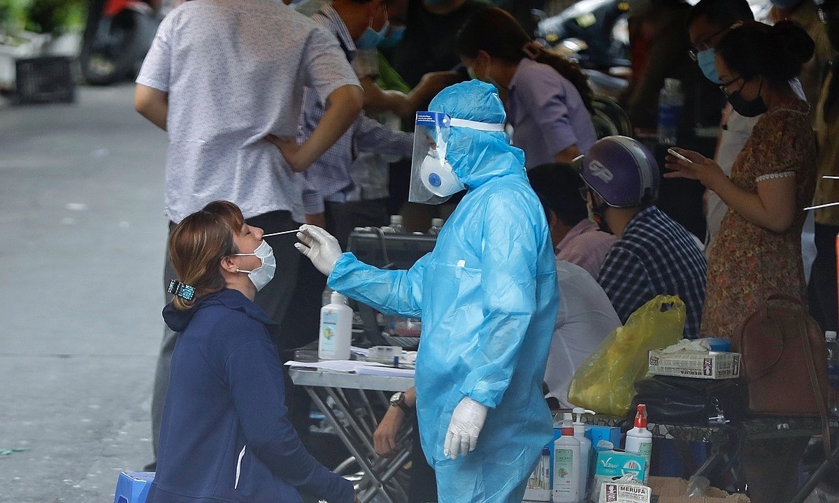 A medical worker takes swab samples from a woman in HCMC for Covid-19 testing, May 21, 2021. Photo by VnExpress/Huu Khoa.