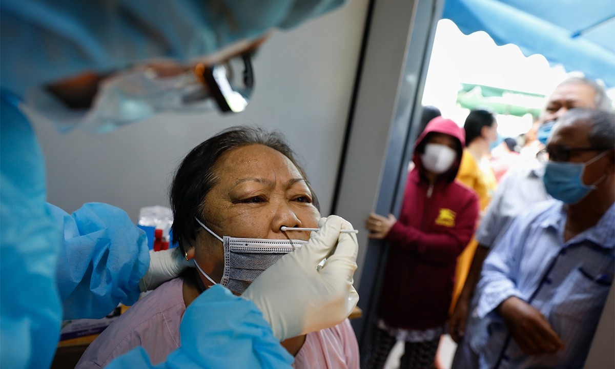 A medical staff takes samples from a woman to test for the novel coronavirus in Ho Chi Minh City, May 13, 2021. Photo by VnExpress/Huu Khoa.