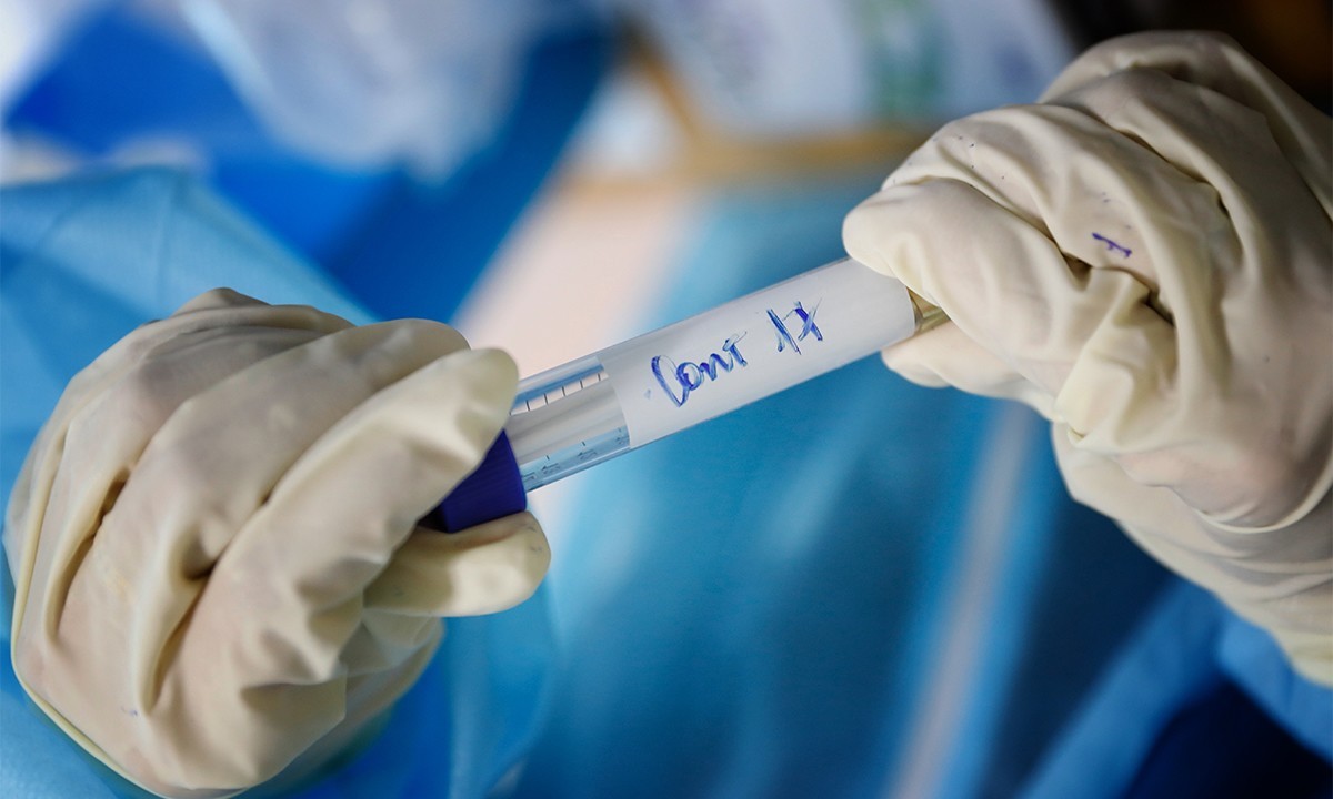 A medical staff holds a container of human samples to test for the novel coronavirus in Ho Chi Minh City. Photo by VnExpress/Huu Khoa.