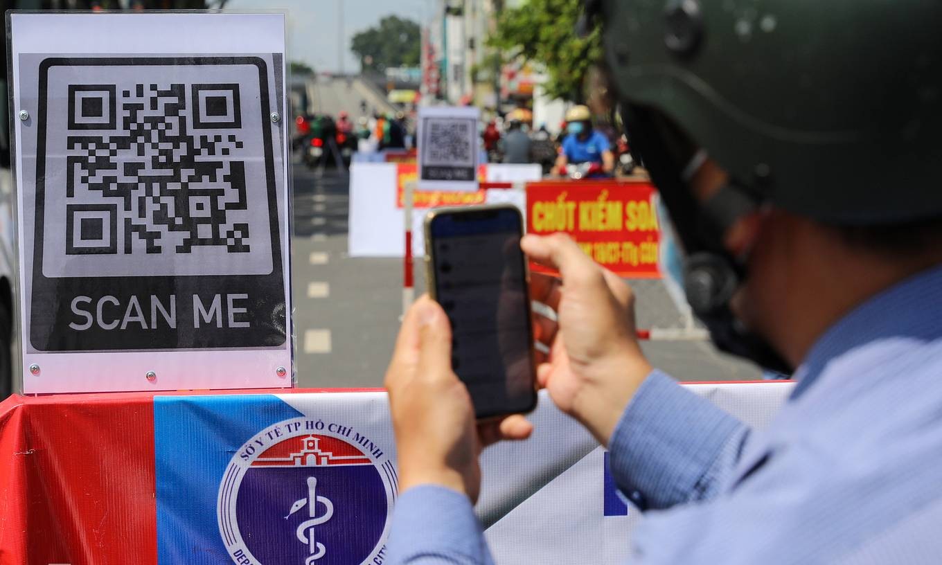 A man scans a QR code to complete the health declaration, one of the procedures everyone has to complete to get through Covid-19 checkpoints at gateways of Go Vap District, now the biggest Covid hotspot in HCMC, June 3, 2021. Photo by VnExpress/Quynh Tran.