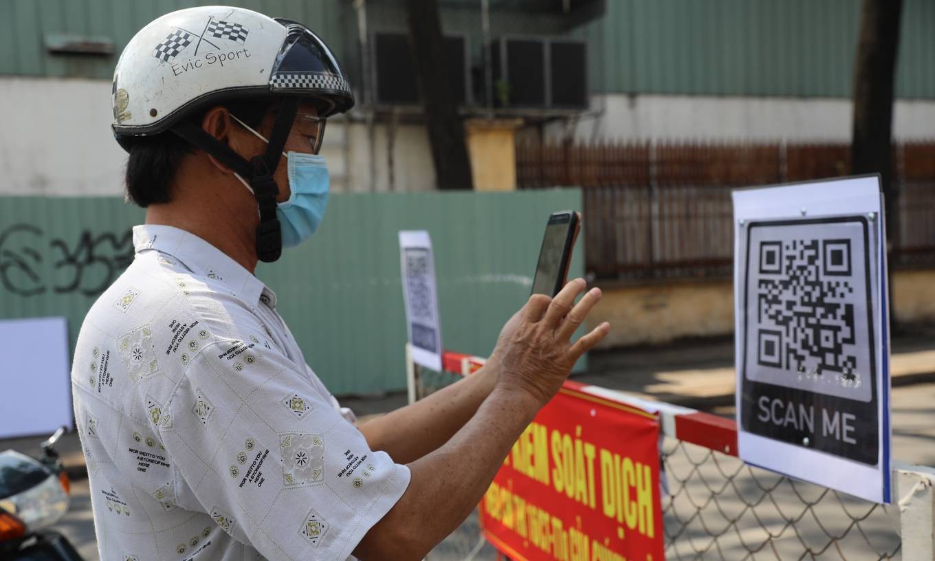 A man scans a QR code to complete the health declaration, one of the procedures everyone has to complete to get through Covid-19 checkpoints in Go Vap District, now the biggest Covid hotspot in HCMC, June 3, 2021. Photo by VnExpress/Quynh Tran.