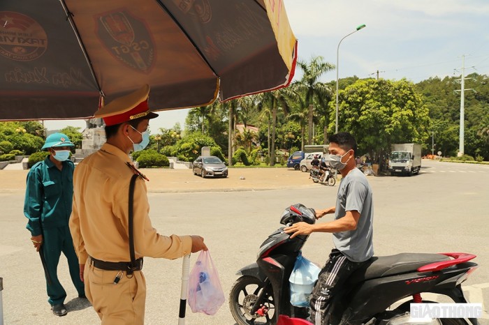 Nhiều người dân chạy đến trao cho các chiến sĩ chốt kiểm soát phòng chống dịch chai nước, ít hoa quả rồi chạy đi khi người nhận chưa kịp hỏi tên, địa chỉ (Ảnh Sỹ Hòa)