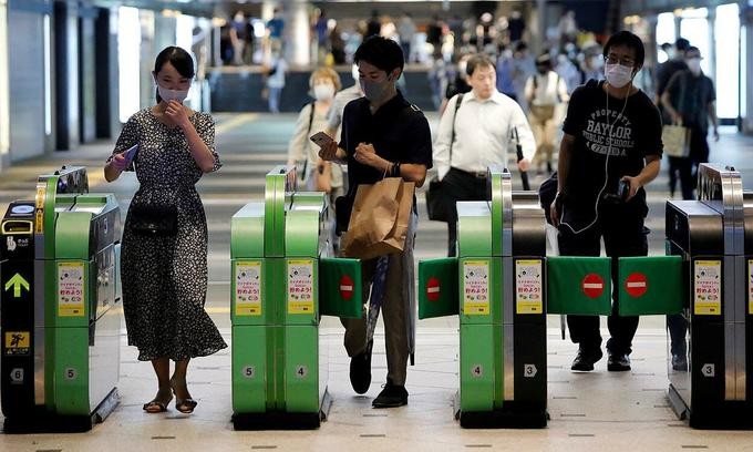 Passengers pass through the automated entrance at a metro station in Tokyo, Japan, July 23, 2020. Photo by Reuters.