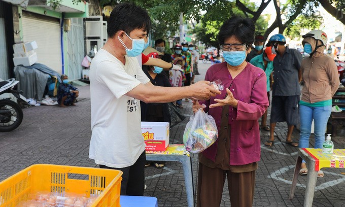 Poor people receive charity good in HCMC, June 28, 2021. Photo by VnExpress/Quynh Tran.