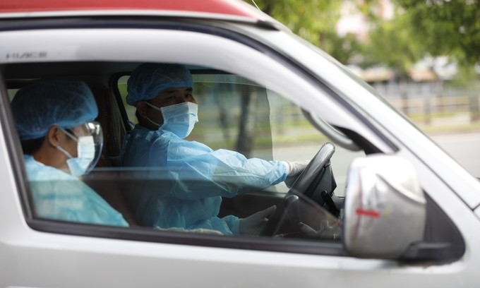 Two medics in an ambulance at the HCMC Hospital for Tropical Diseases. June 13, 2021. Photo by VnExpress/Huu Khoa.