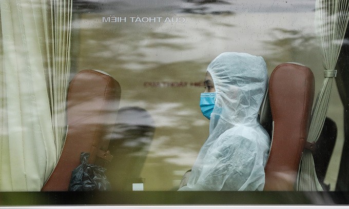 A person in protective suit rides on a coach to a field hospital in HCMC, July 7, 2021. Photo by VnExpress/Huu Khoa.