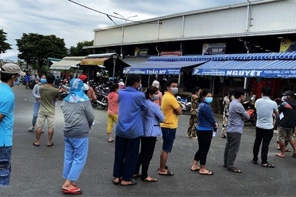 Các tiểu thương đang xếp hàng chờ test nhanh để lấy giấy thông hành và làm cơ sở để vào chợ Bình Điền bán hàng.