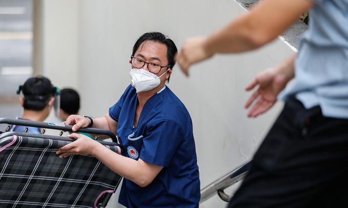 A medical worker carries a folding bed at a field hospital in HCMC, July 11, 2021. Photo by VnExpress/Huu Khoa.