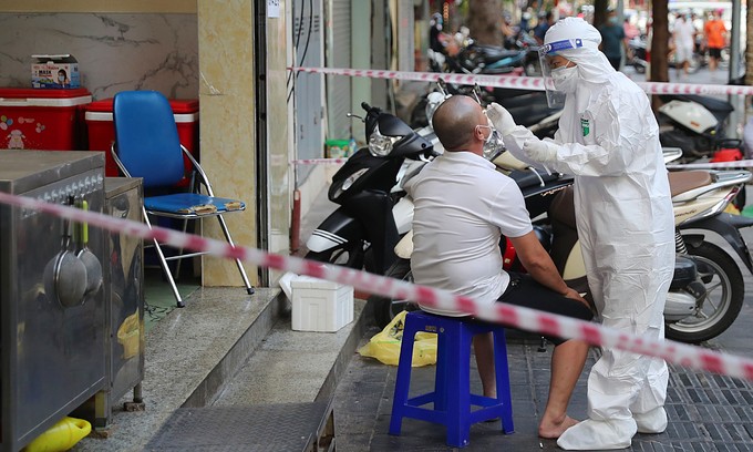 A medic takes samples of a local man at his home in Hanoi, July 11, 2021. Photo by VnExpress/Giang Huy.