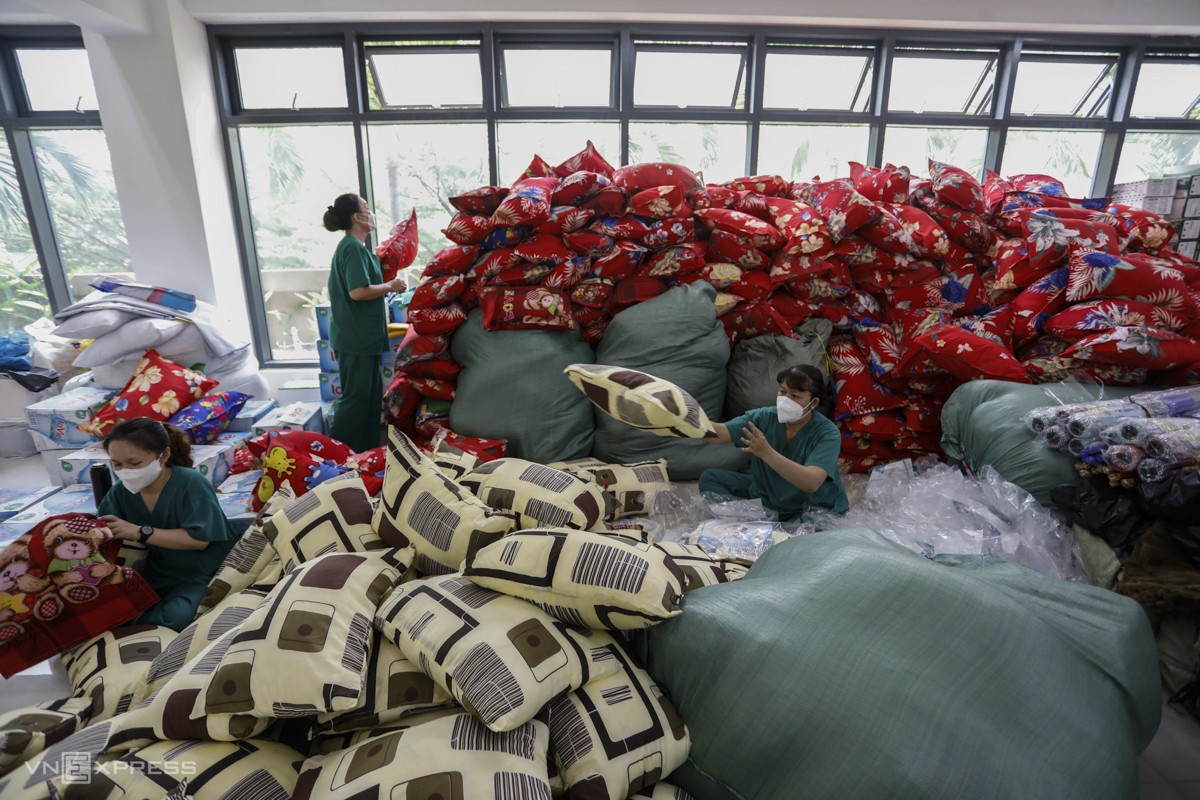 Staff prepare blankets and pillows for patients.
