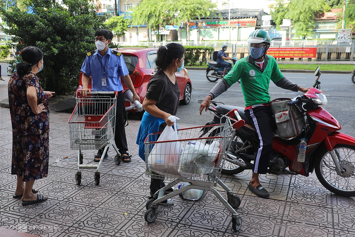 A shipper receives goods from his cusomer at a Co.op Mart supermarket branch on HCMC's Truong Sa Street, July 11, 2021. Photo by VnExpress/Quynh Tran.