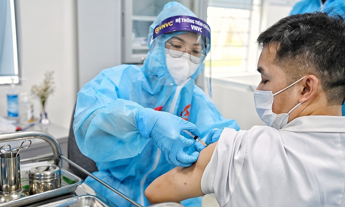 A medical staff injects Covid-19 vaccine into a person in Hanoi on March 8, 2021. Photo by VnExpress/Giang Huy.