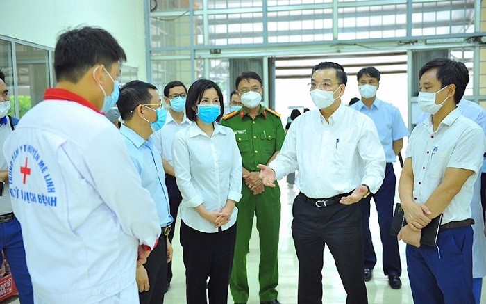 Chairman of the Hanoi People's Committee Chu Ngoc Anh (second from right) inspects Me Linh field hospital. (Photo: NDO/Khai Hung)