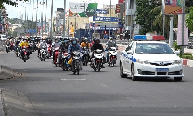 A traffic police vehicle escorts workers stuck in Dong Nai back home in Ninh Thuan Province, July 31 2021. Photo by VnExpress/Thai Ha.