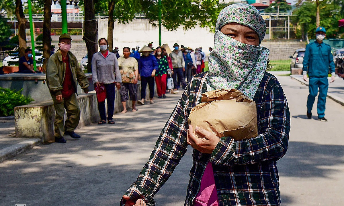 A woman receives free rice in Hanoi's Cau Giay District in April 2020. Photo by VnExpress/Giang Huy.