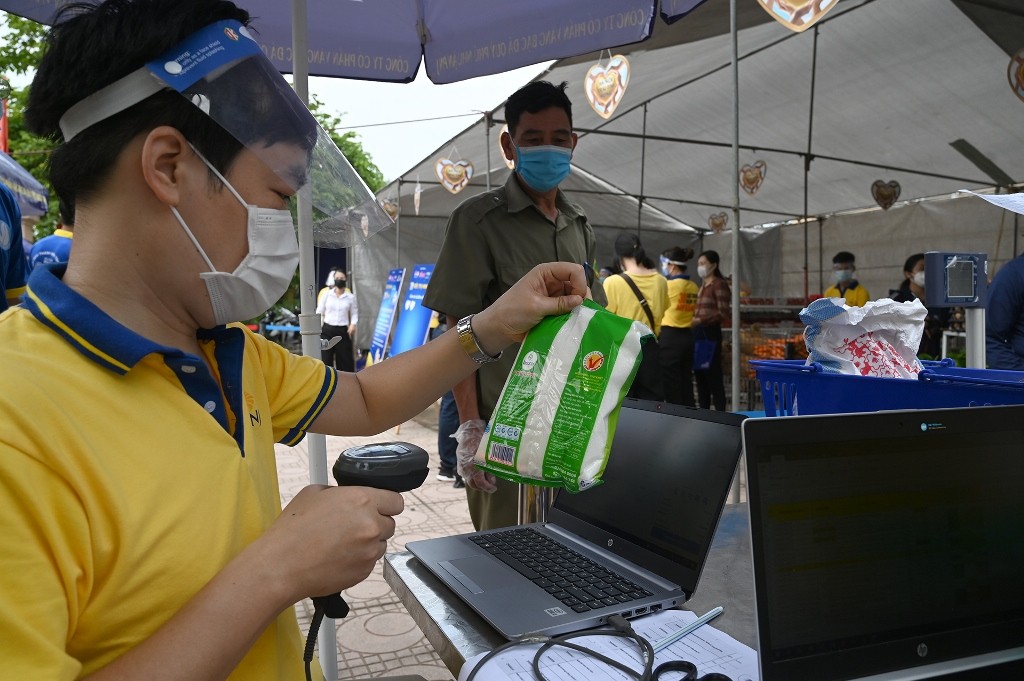 The staff in the mini supermarket help people select and package products.