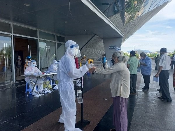 Volunteers instructing people to disinfect and maintain distance before injection. (Photo: NDO)