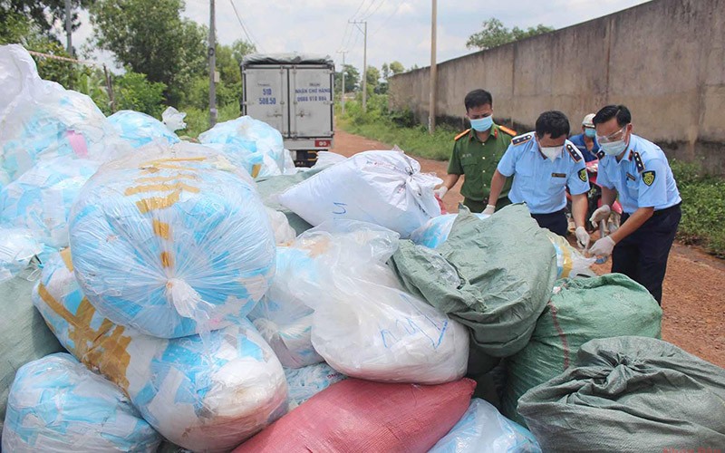 Khẩu trang được đựng trong các bịch nilong và vứt tràn lan dưới mặt đất.