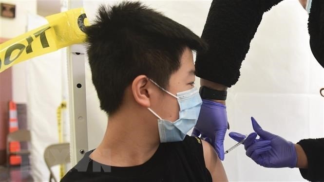 A health worker injecting COVID-19 vaccine to a child in Los Angeles, California, the US. (Photo: AFP/VNA)