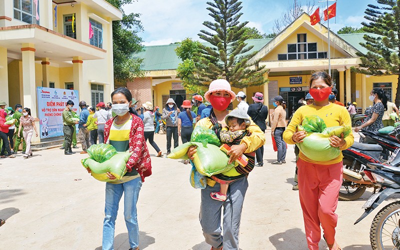 Niềm vui của dân nghèo được một chương trình thiện nguyện hỗ trợ phòng, chống Covid-19. (Ảnh: Hoàng Thiên Nga)