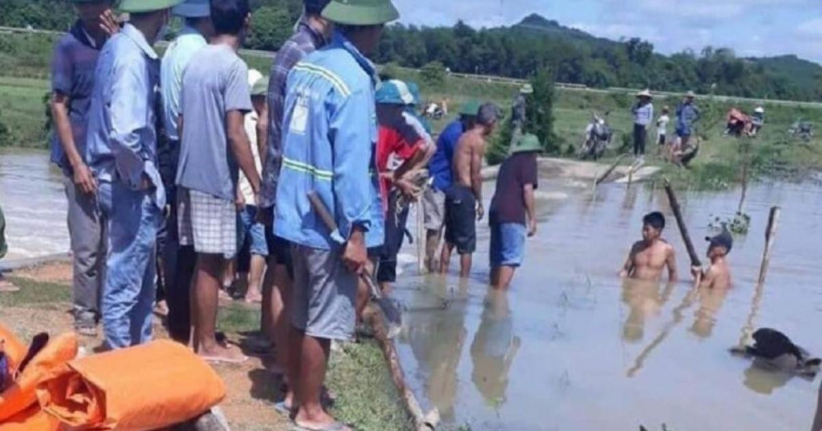 Người dân và lực lượng chức năng sử dụng cọc tre, bao tải ngăn bớt dòng chảy trên đập tràn để tìm kiếm thi thể em H. (Ảnh F.B)